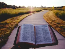 Une Bible dehors sur une table au lever du soleil