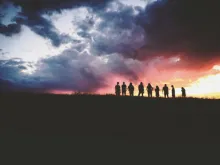 Les silhouettes des personnes devant un coucher du soleil