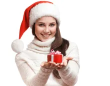 Une femme coiffée d'un bonnet de bas de Noël tenant un cadeau.