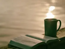 Une Bible est une tasse au bord de l'eau