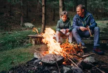 Père avec son fils assis ensemble devant un feu