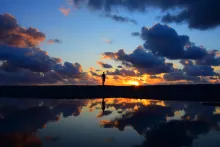 La silhouette d'une personne dans un coucher de soleil.