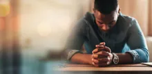 Un homme priant à une table