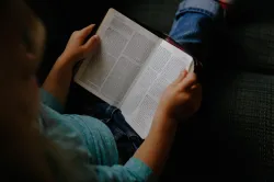 femme avec une bible ouverte sur les genoux