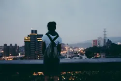 Une jeune femme regarde une ville depuis un belvédère
