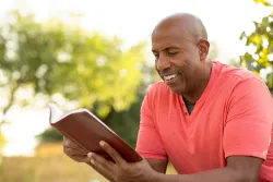 Un homme qui lit une Bible.