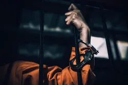 Un homme dans une prison avec des menottes.