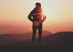 La silhouette d'un homme avec des montagnes à l'arrière-plan