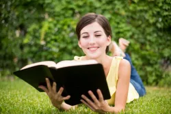 Une femme souriante lit la Bible