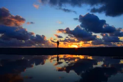La silhouette d'une personne dans un coucher de soleil.